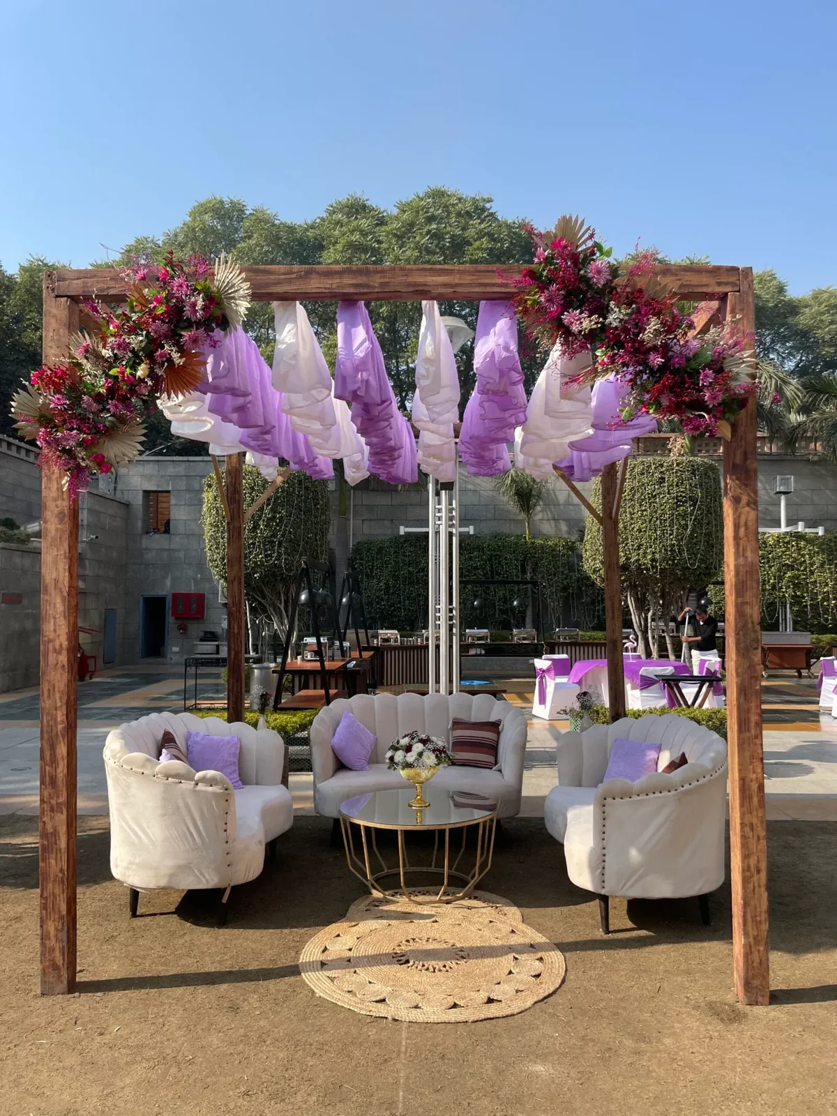 White scalloped sofas beneath lavender drapes and pink flowers
